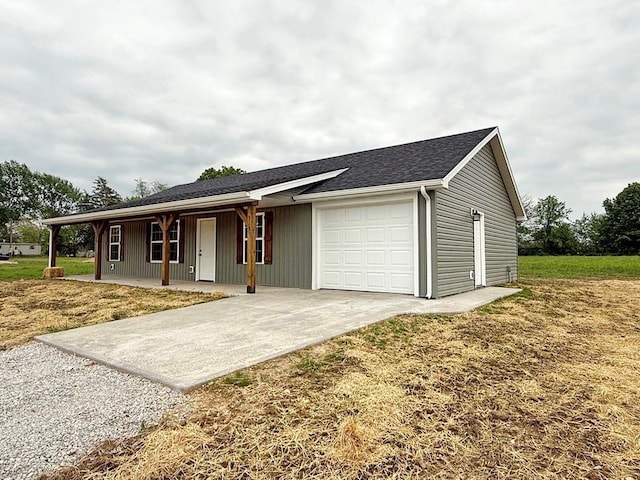 view of front of house with covered porch, an attached garage, driveway, and a front yard