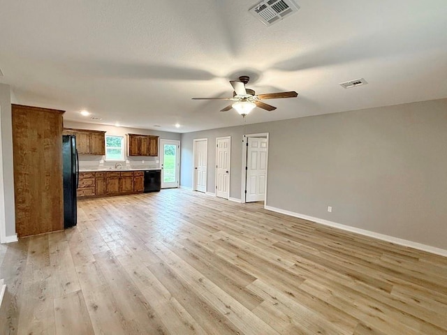 unfurnished living room with baseboards, visible vents, ceiling fan, and light wood-type flooring