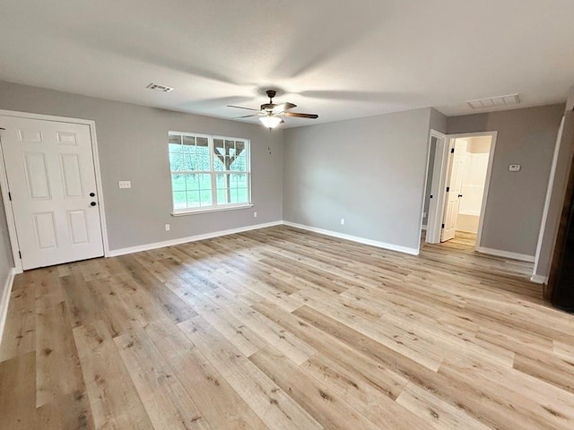 interior space with visible vents, a ceiling fan, light wood-style floors, and baseboards