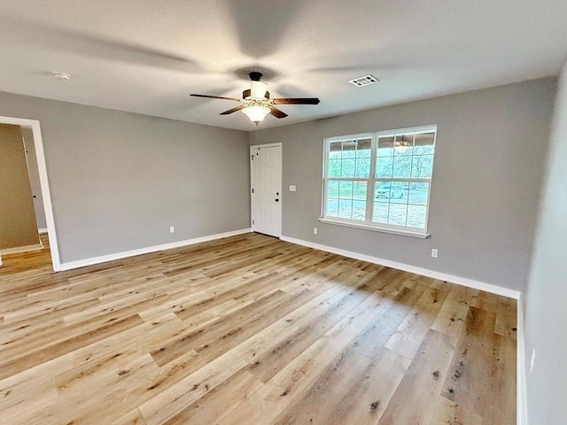 unfurnished room featuring visible vents, baseboards, ceiling fan, and wood finished floors