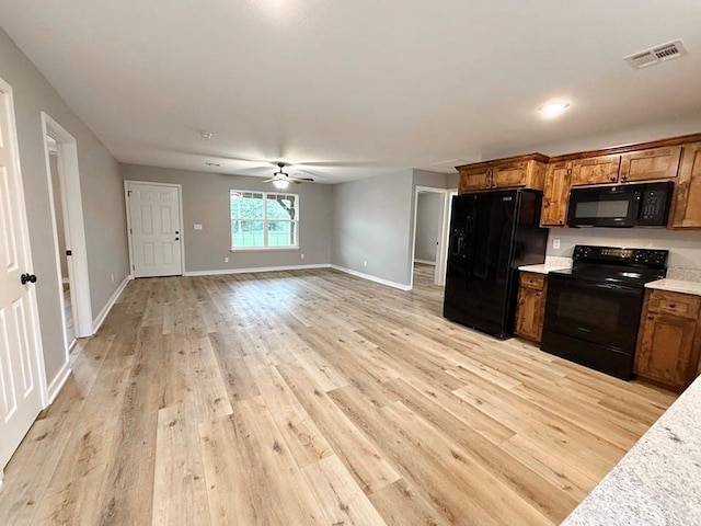 kitchen featuring visible vents, light countertops, brown cabinetry, and black appliances