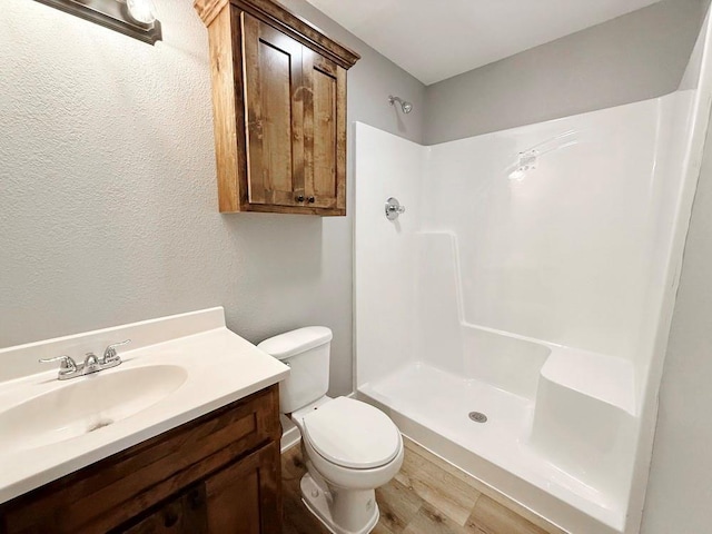 full bath with toilet, walk in shower, and vanity