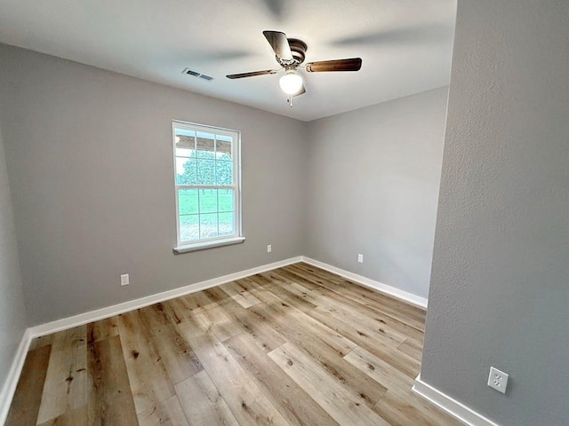 unfurnished room featuring visible vents, baseboards, ceiling fan, and wood finished floors