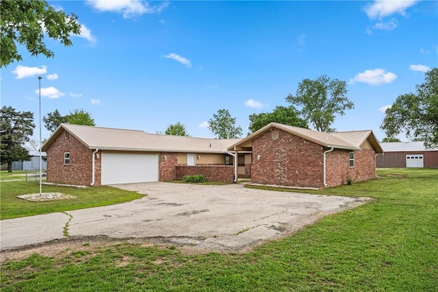 ranch-style house with an attached garage, a front lawn, brick siding, aphalt driveway, and metal roof