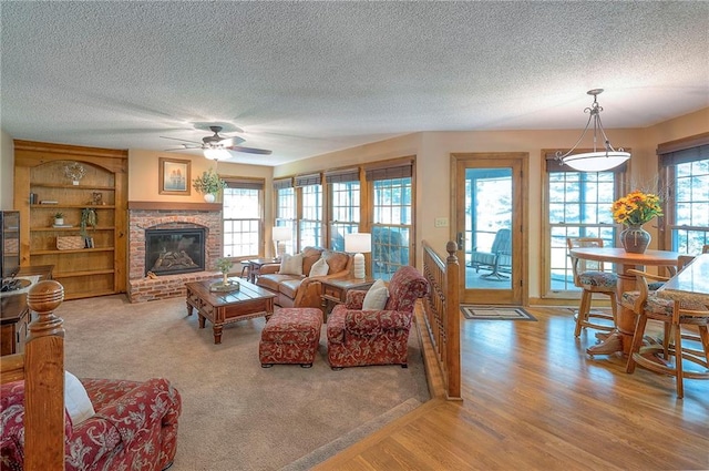 14241 W 113th Ter, Olathe, KS 66062 - living room featuring ceiling fan, a textured ceiling, a fireplace, and wood finished floors