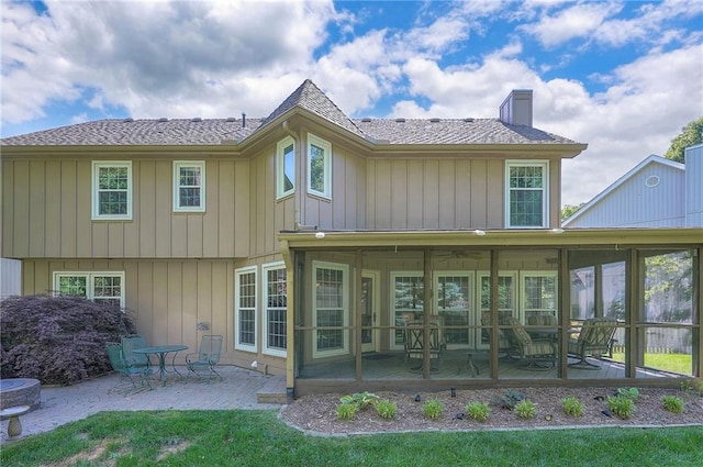 14241 W 113th Ter, Olathe, KS 66062 - back of property featuring a chimney, a patio area, a sunroom, and roof with shingles