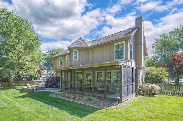 14241 W 113th Ter, Olathe, KS 66062 - back of house with a sunroom, a shingled roof, a fire pit, and a chimney