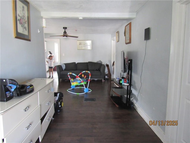 living room with a ceiling fan, wood finished floors, and beam ceiling