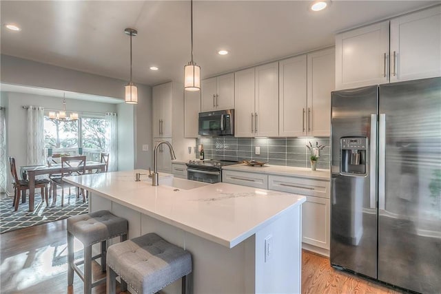 4016 W 79th St, Prairie Village, KS 66208 - kitchen featuring a sink, light wood-style floors, light countertops, stainless steel appliances, and recessed lighting