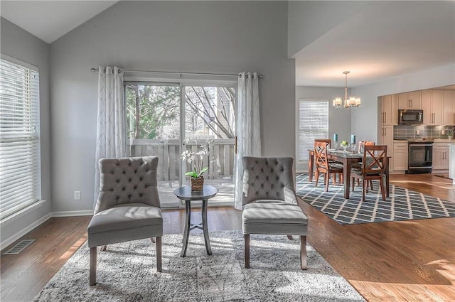 4016 W 79th St, Prairie Village, KS 66208 - sitting room featuring an inviting chandelier, vaulted ceiling, wood finished floors, and a healthy amount of sunlight