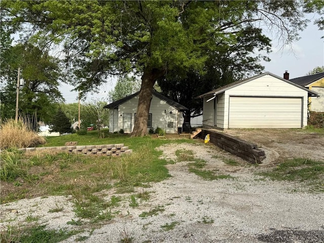 exterior space with an outdoor structure, a garage, and driveway