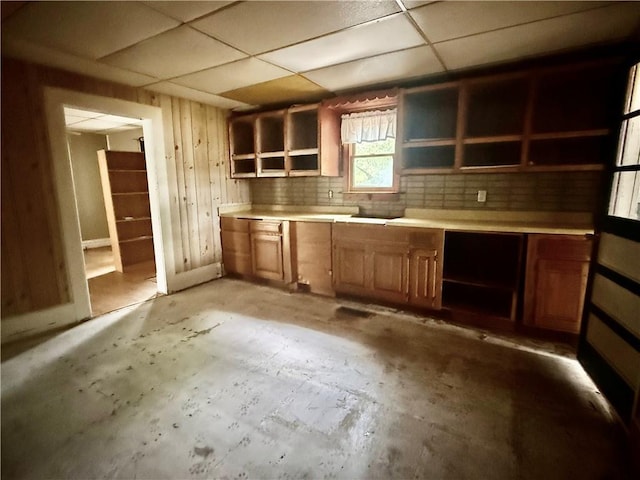 kitchen featuring open shelves, brown cabinetry, and a paneled ceiling