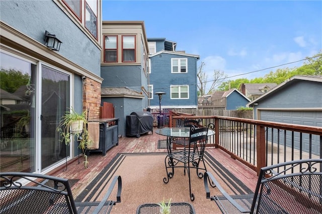 3804 Harrison St, Kansas City, MO 64109 - deck featuring area for grilling, fence, and a detached garage