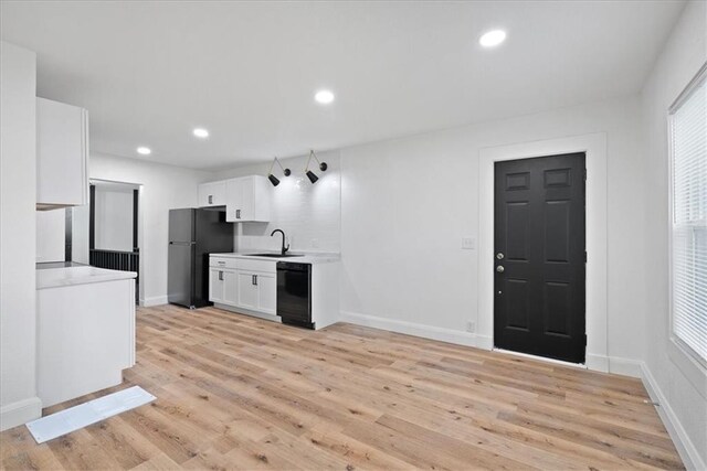 15015 E Truman Rd, Independence, MO 64050 - kitchen featuring a sink, light countertops, white cabinetry, light wood-type flooring, and black appliances