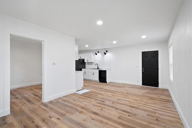 15015 E Truman Rd, Independence, MO 64050 - unfurnished living room featuring recessed lighting, a sink, light wood finished floors, and baseboards