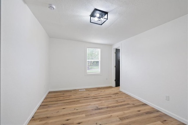 15015 E Truman Rd, Independence, MO 64050 - empty room featuring light wood-style floors, baseboards, and a textured ceiling