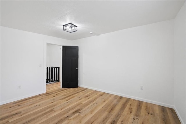 15015 E Truman Rd, Independence, MO 64050 - unfurnished room featuring baseboards, light wood-type flooring, and a textured ceiling