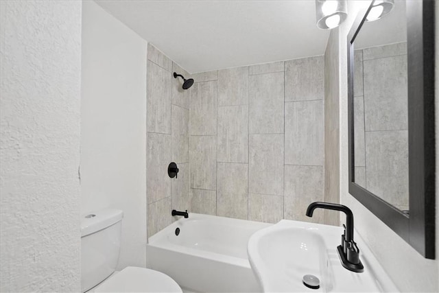 15015 E Truman Rd, Independence, MO 64050 - full bathroom featuring a sink, a textured wall, tub / shower combination, and toilet
