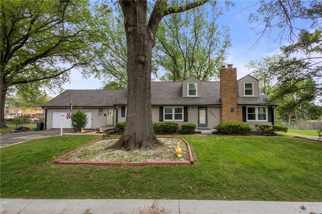 2111 Lombardy Dr, Kansas City, KS 66102 - new england style home featuring fence, an attached garage, a front lawn, a chimney, and driveway