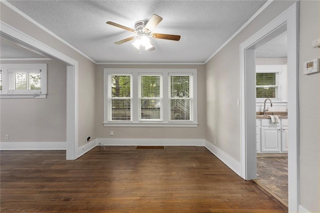 708 N River Blvd, Independence, MO 64050 - empty room with crown molding, dark wood-style floors, plenty of natural light, a textured ceiling, and a ceiling fan