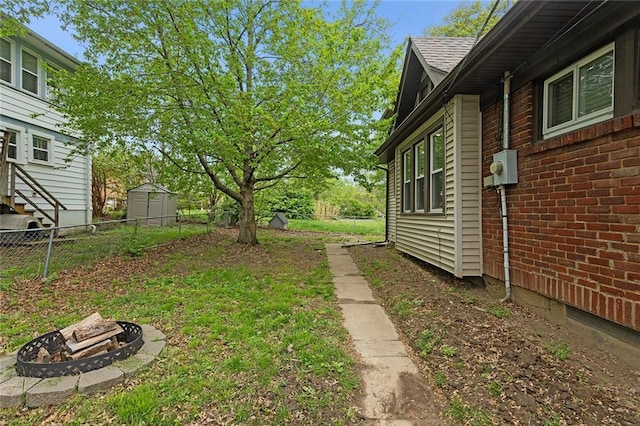 708 N River Blvd, Independence, MO 64050 - view of yard featuring a storage unit, an outdoor fire pit, and fence