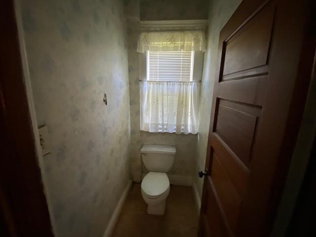 bathroom with baseboards and toilet