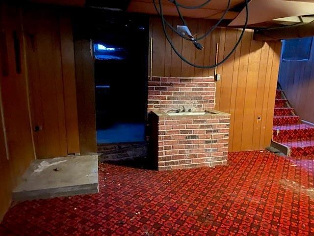 interior space with carpet flooring and wooden walls