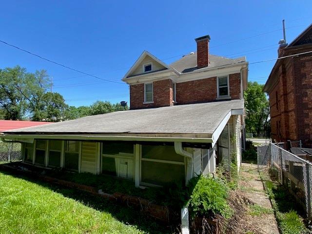 back of property with fence and a chimney