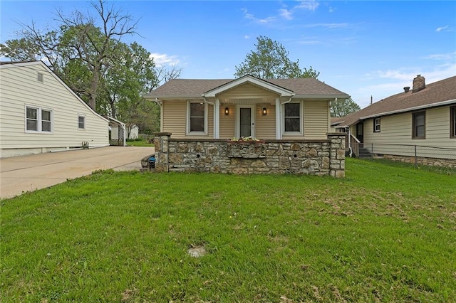 4433 N Jackson Ave, Kansas City, MO 64117 - bungalow-style house featuring fence, a front lawn, and stone siding