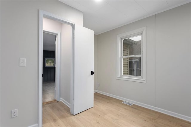 4433 N Jackson Ave, Kansas City, MO 64117 - unfurnished room with visible vents, light wood-style flooring, crown molding, and baseboards