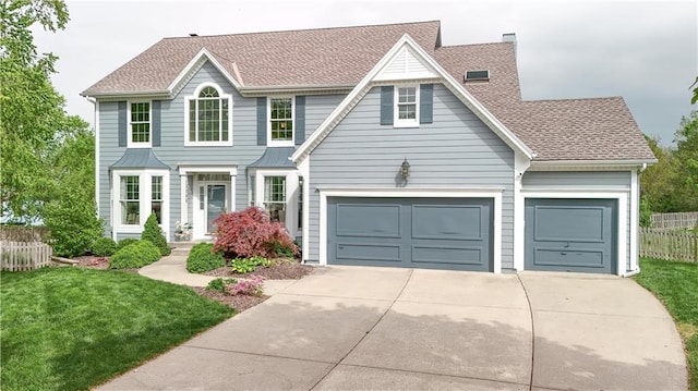 view of front of house with fence, roof with shingles, a front lawn, a garage, and driveway
