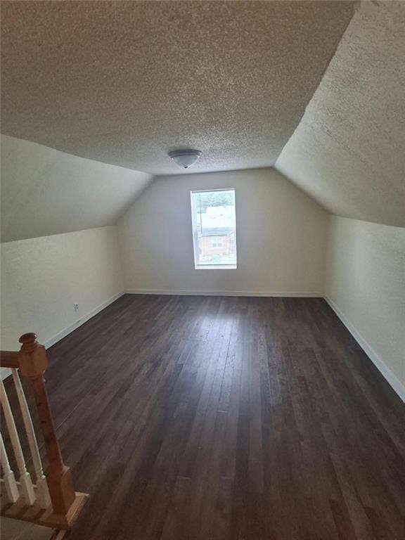 104 S 13th St, Kansas City, KS 66102 - additional living space featuring baseboards, dark wood finished floors, a textured ceiling, and lofted ceiling