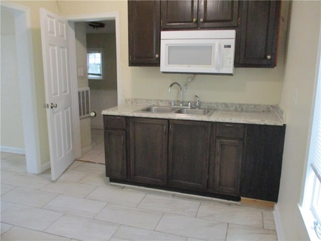 104 S 13th St, Kansas City, KS 66102 - kitchen with white microwave, light countertops, and dark brown cabinetry