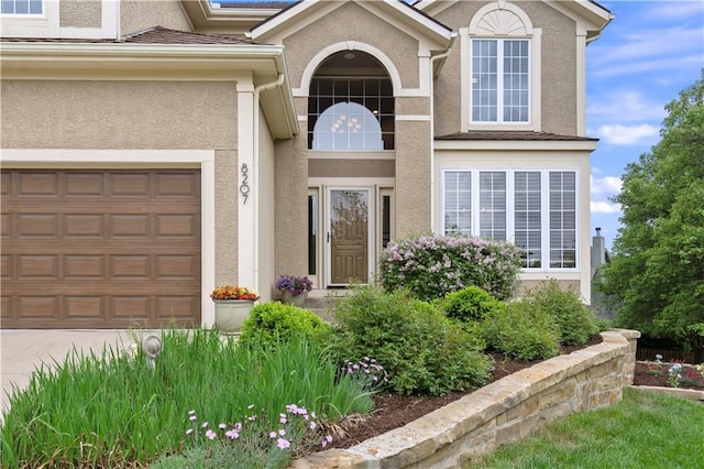 property entrance with driveway and stucco siding