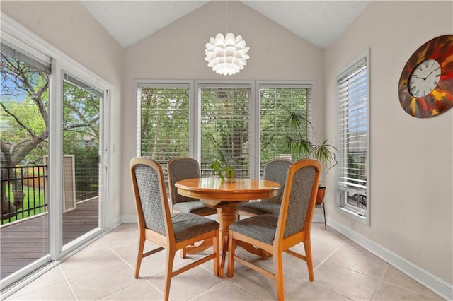 dining room with baseboards, lofted ceiling, and light tile patterned floors