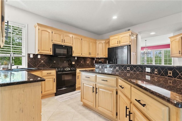 kitchen featuring a sink, dark stone countertops, black appliances, and light brown cabinets