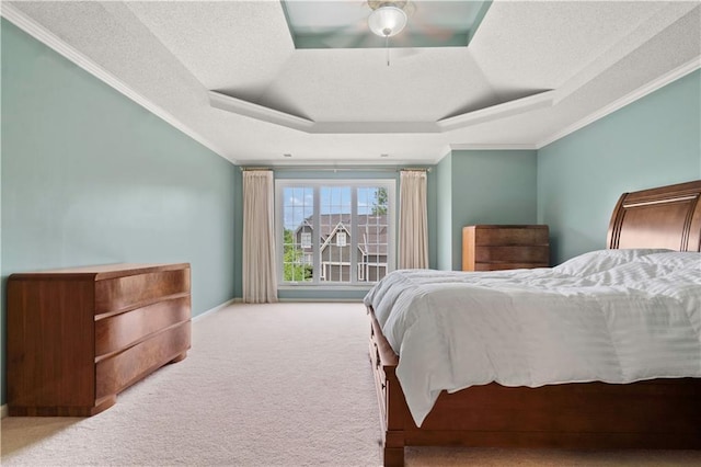 carpeted bedroom featuring crown molding, a textured ceiling, a tray ceiling, and a ceiling fan