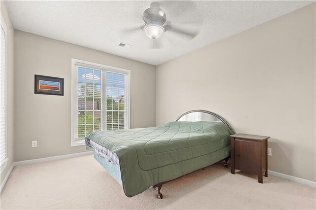 carpeted bedroom featuring a ceiling fan, baseboards, and visible vents