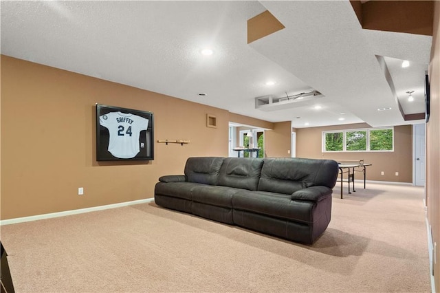 living area featuring baseboards, recessed lighting, a textured ceiling, and light carpet