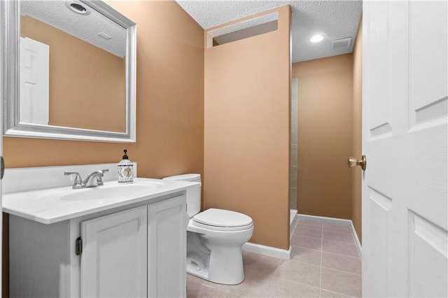 bathroom with tile patterned flooring, a textured ceiling, toilet, and vanity