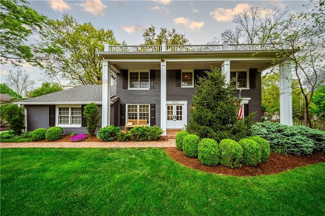 view of front facade featuring a front lawn, brick siding, and covered porch