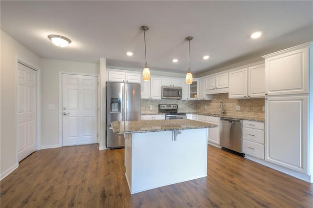 kitchen with a sink, a center island, white cabinets, and stainless steel appliances