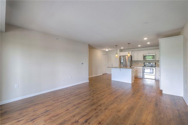 unfurnished living room with baseboards, recessed lighting, and dark wood-style floors