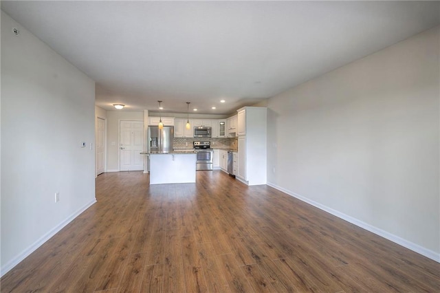 unfurnished living room featuring dark wood-style flooring and baseboards