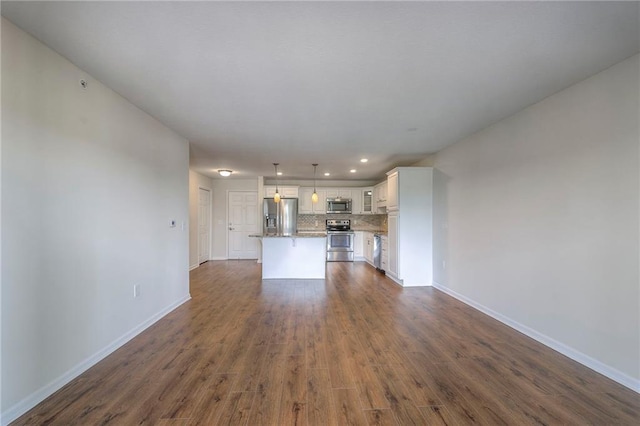 unfurnished living room featuring recessed lighting, baseboards, and dark wood-style floors