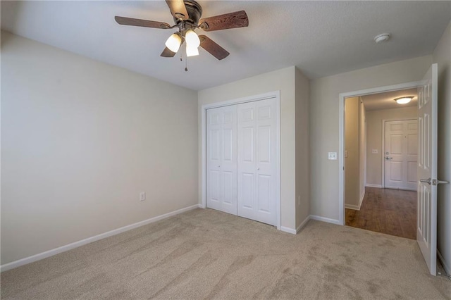 unfurnished bedroom featuring a closet, carpet, ceiling fan, and baseboards