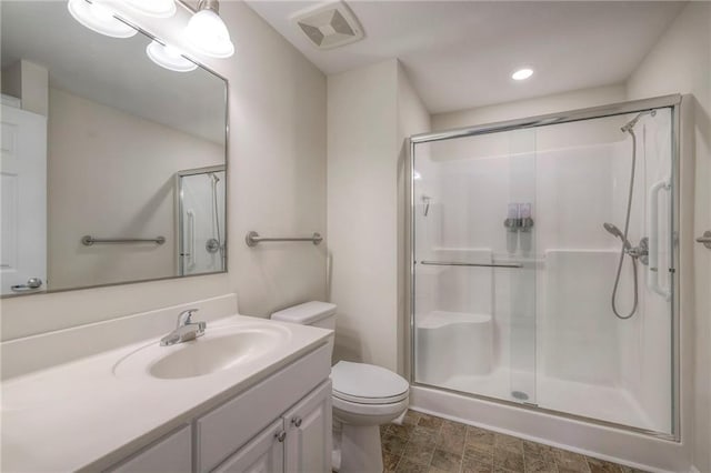 full bath with visible vents, a stall shower, toilet, and vanity