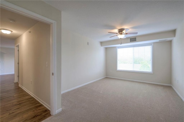 unfurnished room featuring carpet floors, baseboards, visible vents, and ceiling fan