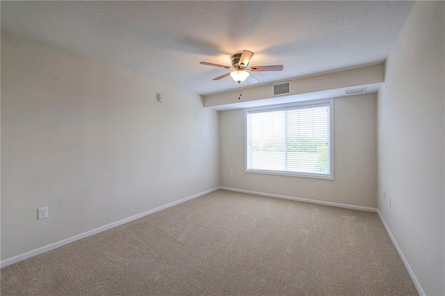 unfurnished room with ceiling fan, visible vents, light carpet, and baseboards