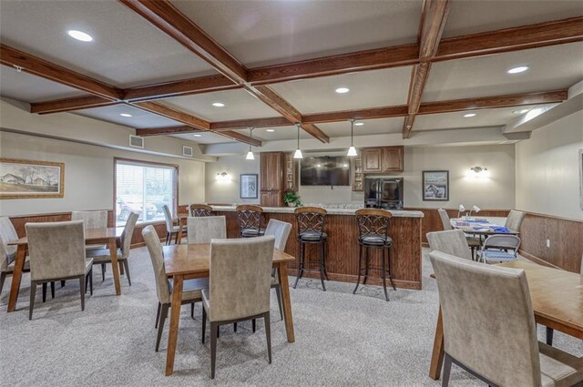 dining area with coffered ceiling, beam ceiling, and light colored carpet